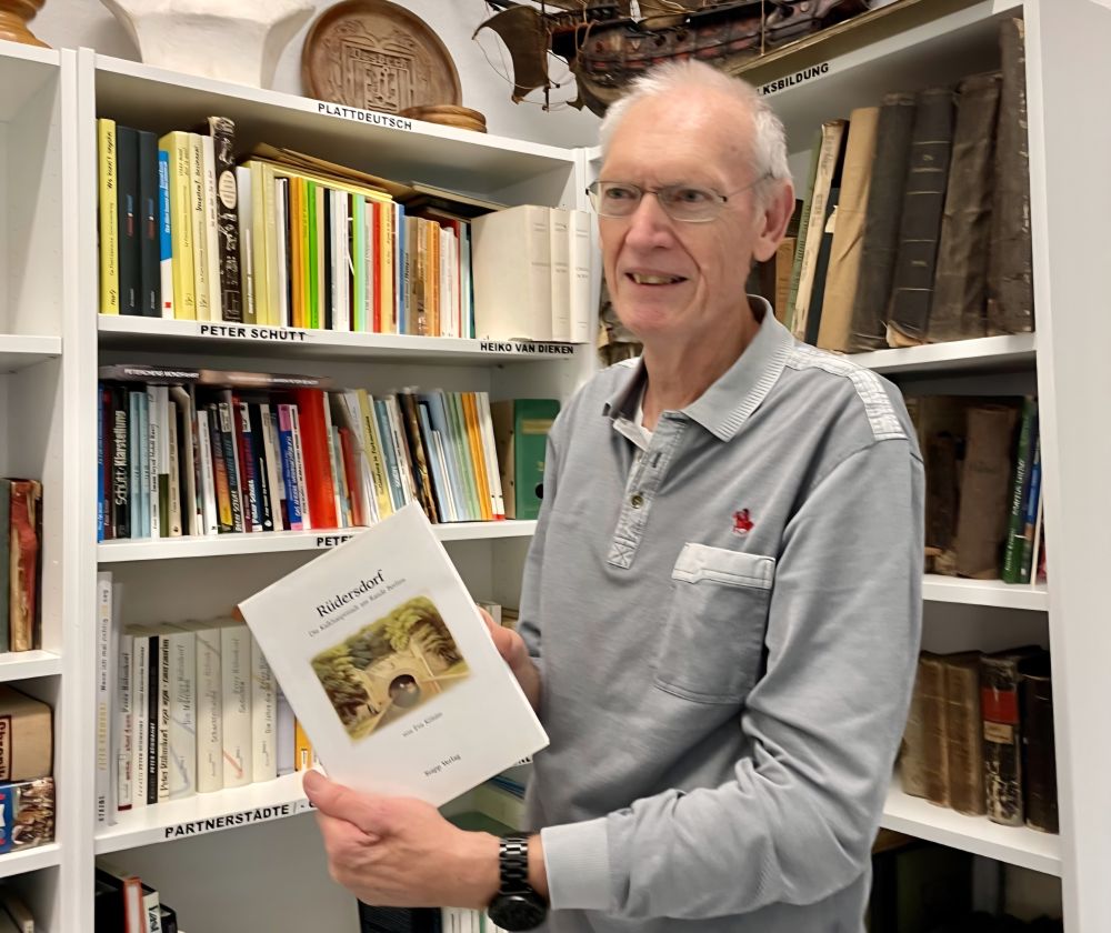 rainer kuppke der langjaehrige vorsitzende des vereins vor der bueste und der buchsammlung